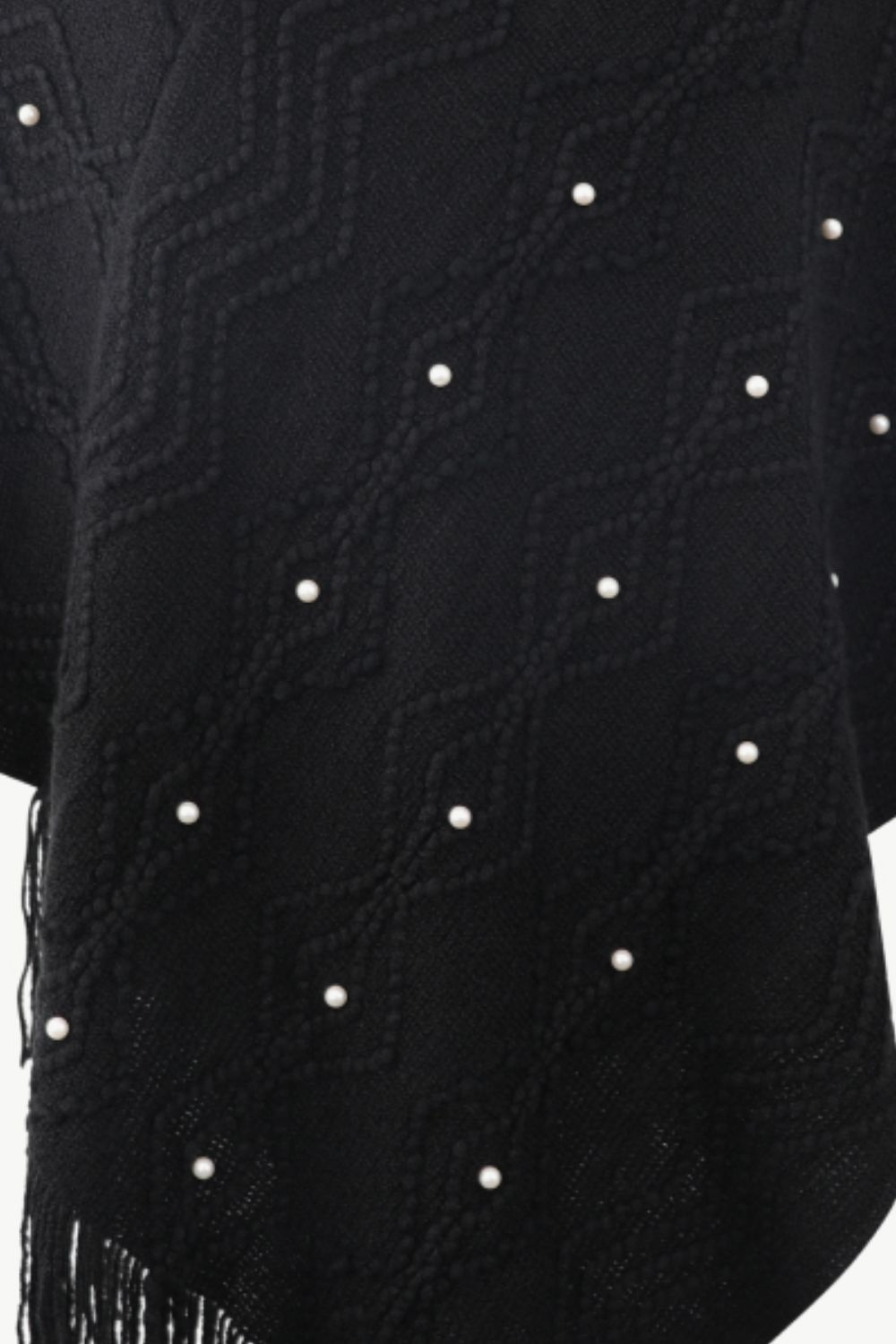 Close up of Black poncho with faux pearl and fringe trim
