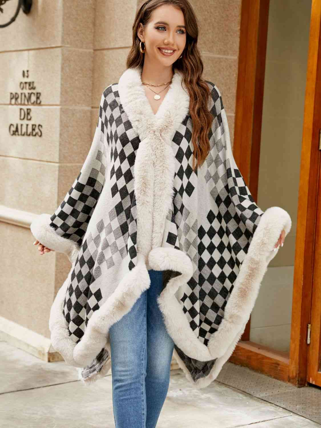 Model wearing checkered poncho with faux fur trim