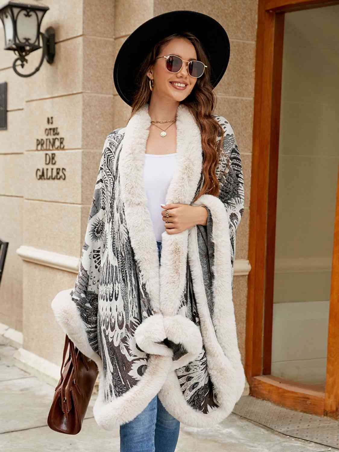 Model wearing open front printed poncho with faux fur trim
