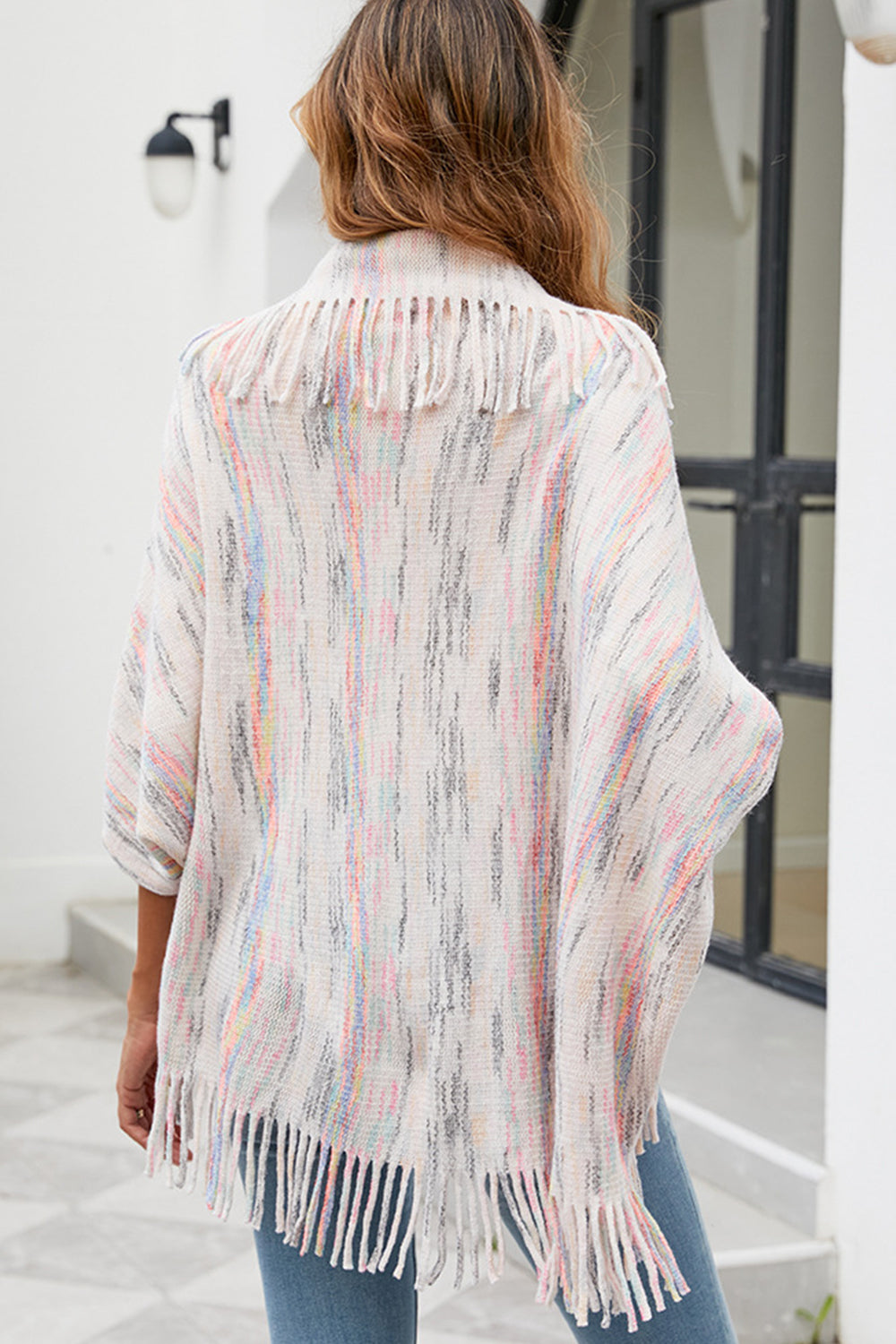 Back of model wearing open front ivory fringe poncho