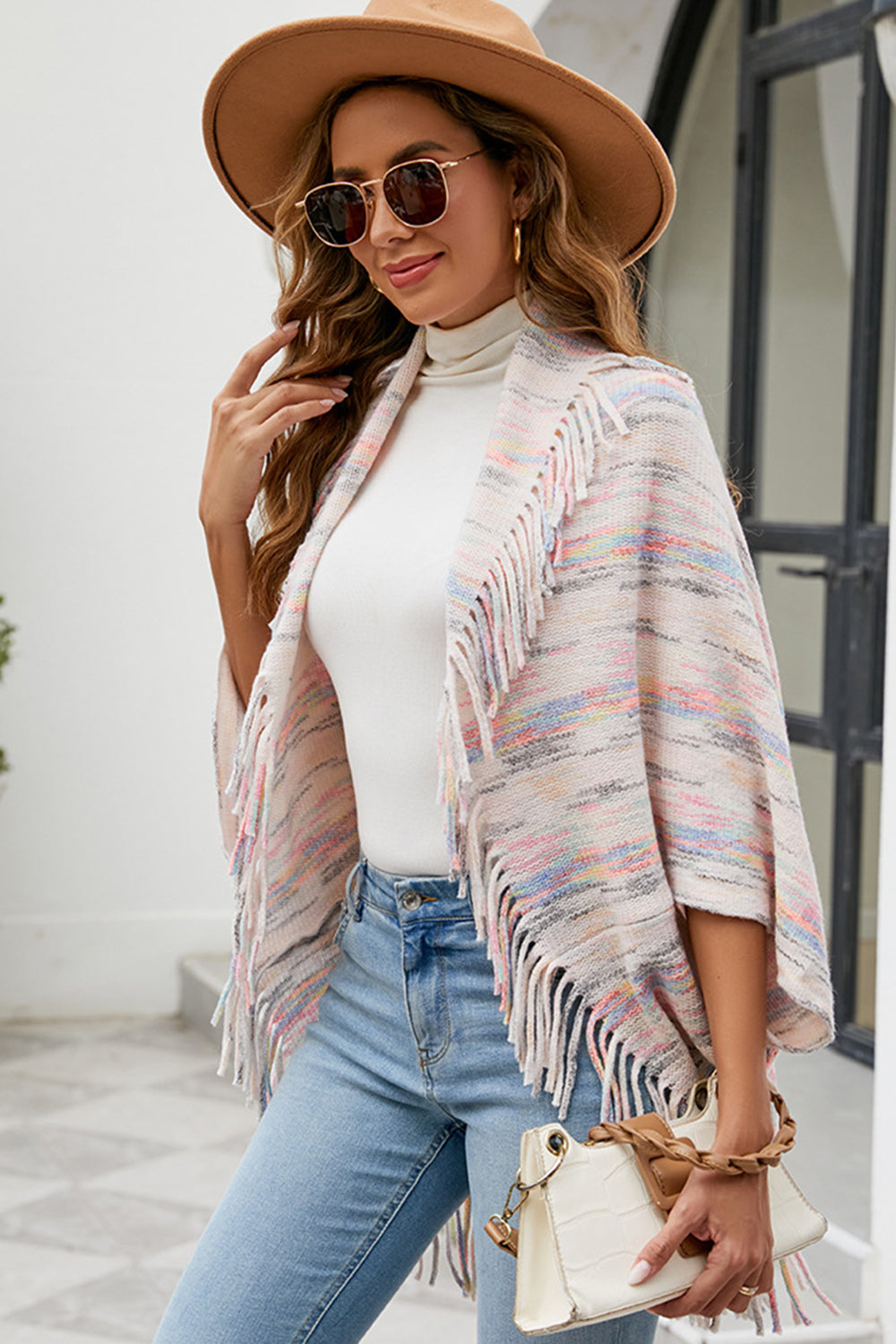 Model wearing open front ivory fringe poncho