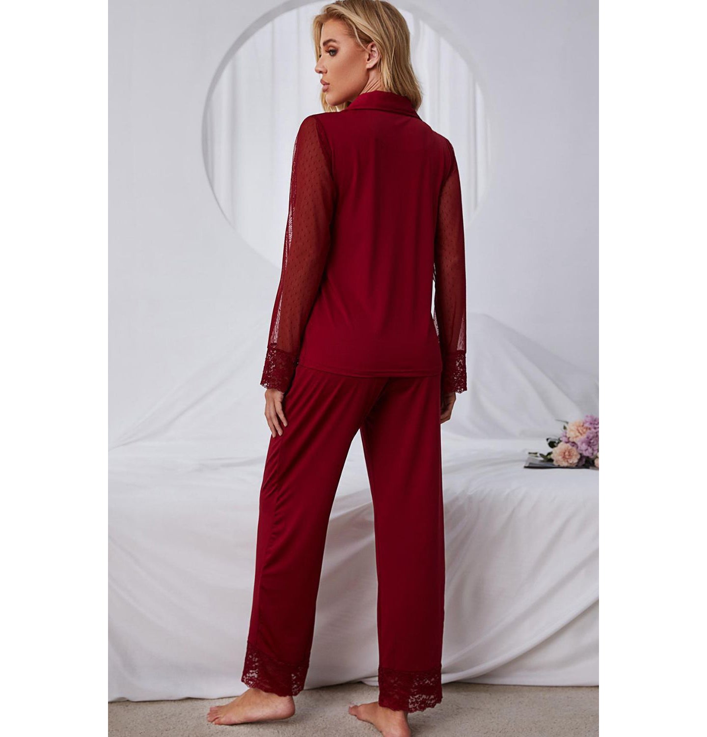 Back of model standing wearing red pajama set with lace arms