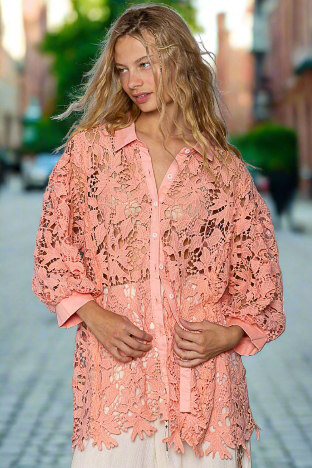 Model wearing peach coral lace shirt