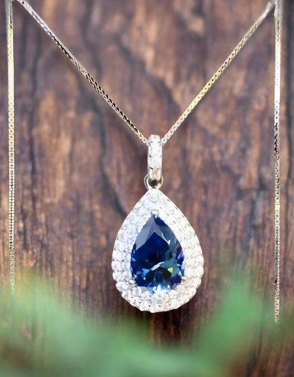 2 carat blue Moissanite teardrop pendant with zircon accent stones set in platinum plated sterling silver
