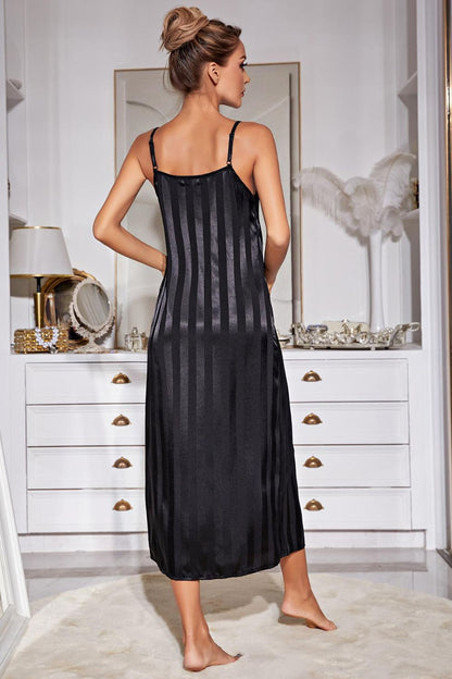 Back view of woman standing in front of dresser wearing black striped nightgown