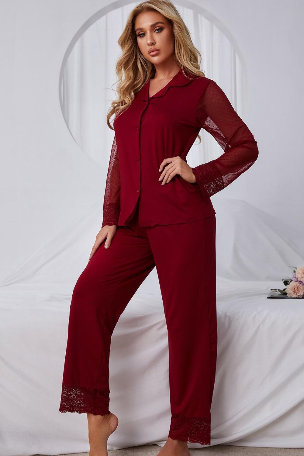 Model standing wearing red pajama set with lace arms