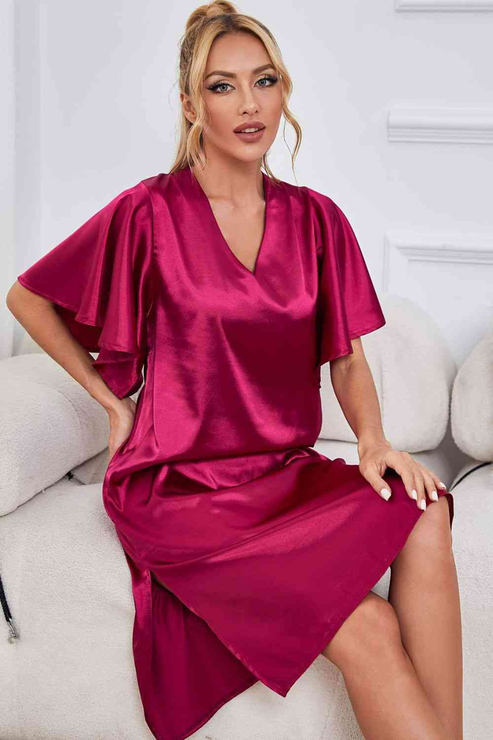 Model sitting on sofa wearing pink knee length nightgown