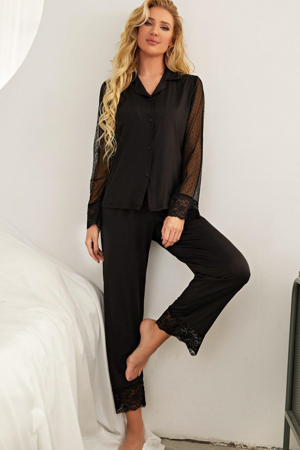 Model standing wearing black pajama set with lace arms