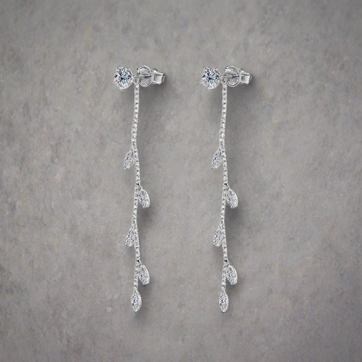 Moissanite drop earrings set in sterling silver leaf setting