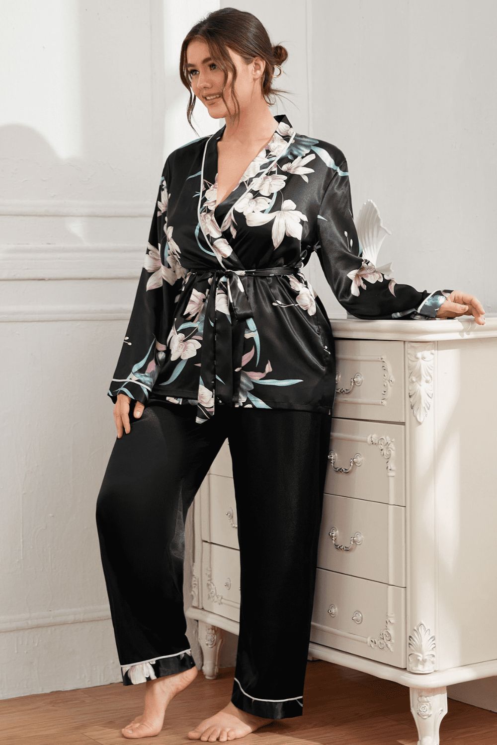 Model wearing black plus size pajama set with floral print