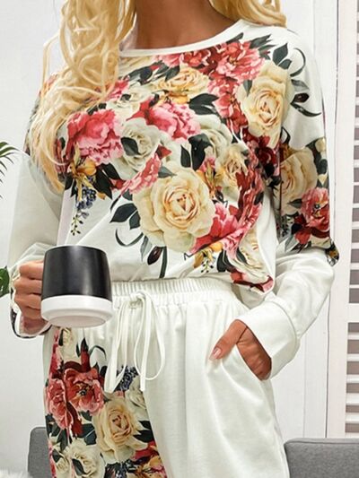 Close up view of model holding cup of coffee wearing white pajama set with flower print