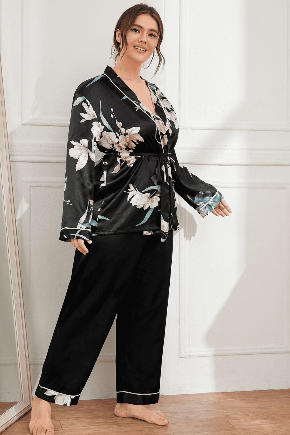 Model wearing black plus size pajama set with floral print