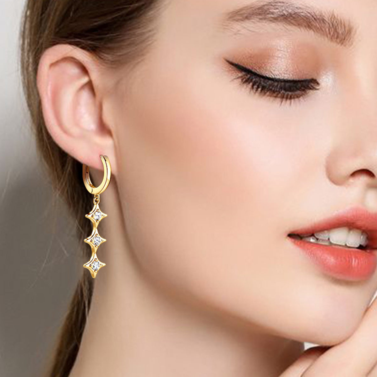 Model wearing moissanite and gold plated sterling earrings