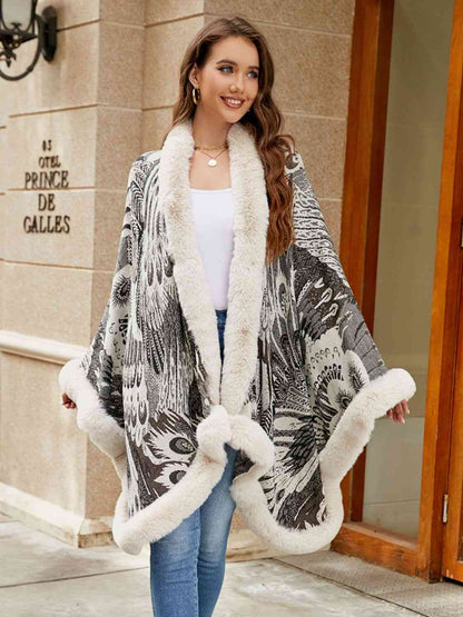 Model wearing open front printed poncho with faux fur trim