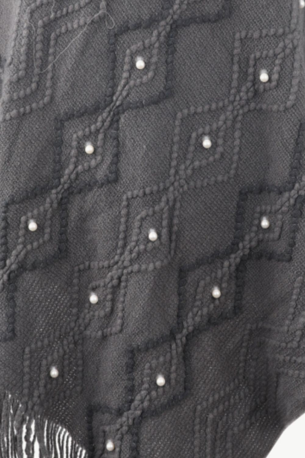 Close up of Gray poncho with faux pearl and fringe trim